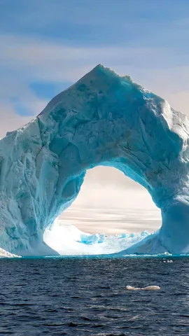 Natural arch carved in an iceberg, Antarctica